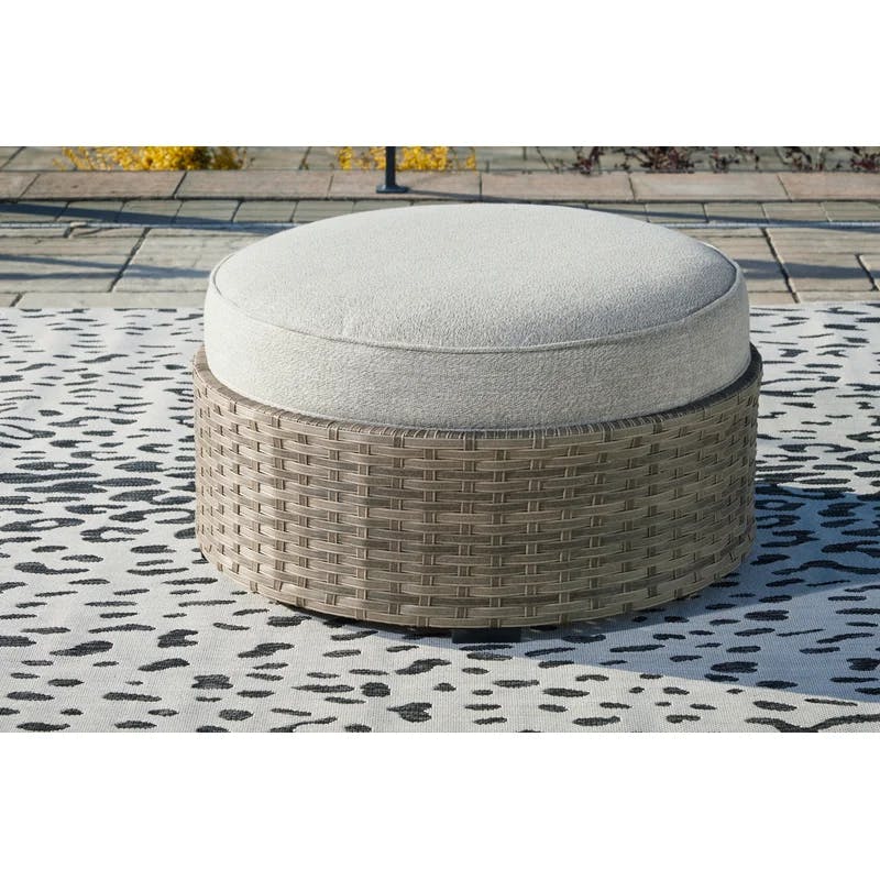 Calworth Handwoven Wicker Outdoor Ottoman with Performance Beige Cushion